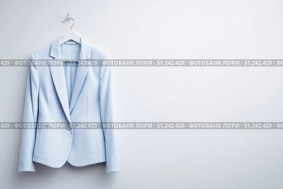 Women's business blazer without human model. Female office classic light blue jacket, coat for ladies with button, long sleeves hanging on a hanger on white background. Mock up, template. Suit jacket. Стоковое AI-изображение, AI-художник Марина Демидюк / Фотобанк Лори