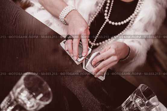 women’s hands sharper prevents a deck of cards in an underground casino. close-up. Стоковое фото, агентство Ingram Publishing / Фотобанк Лори