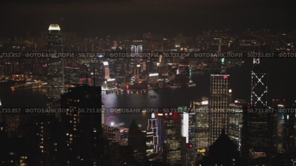 Wonderful aerial view of skyscrapers in downtown and Victoria Harbor in Hong Kong at night. Awesome cityscape. Hong Kong is a popular tourist destination of Asia. Редакционное видео, видеограф Ирина Михайличенко / Фотобанк Лори