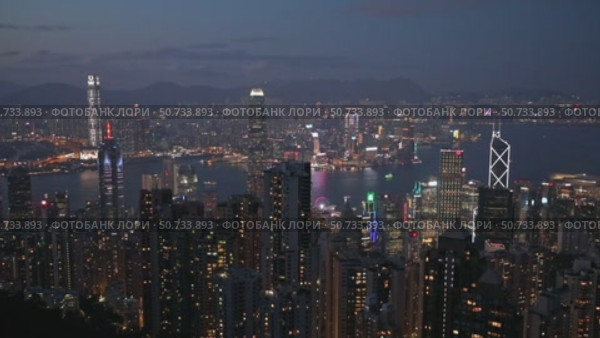 Wonderful aerial view of skyscrapers in downtown and Victoria Harbor in Hong Kong at night. Awesome cityscape. Hong Kong is a popular tourist destination of Asia. Редакционное видео, видеограф Ирина Михайличенко / Фотобанк Лори