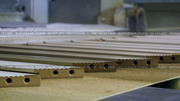 Wooden parts are being varnished or primed on modern woodworking equipment. 4K. Стоковое видео, видеограф ActionStore / Фотобанк Лори