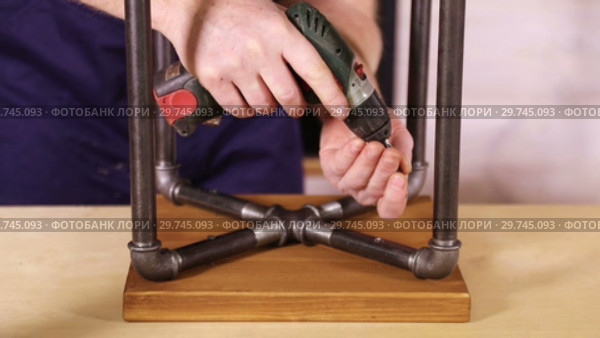 Worker fastens the screws with the screwdriver in the stool closeup. Стоковое видео, видеограф Алексей Кузнецов / Фотобанк Лори