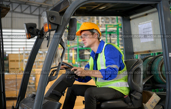 Worker in auto parts warehouse use a forklift to work to bring the box of auto parts into the storage shelf of the warehouse waiting for delivery to the car assembly line. Стоковое фото, агентство Ingram Publishing / Фотобанк Лори