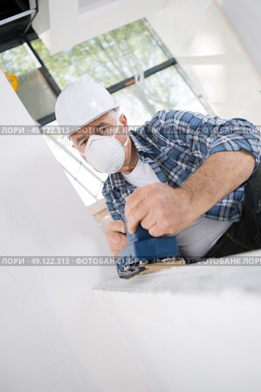 worker in protective mask working with sander. Стоковое фото, агентство Ingram Publishing / Фотобанк Лори