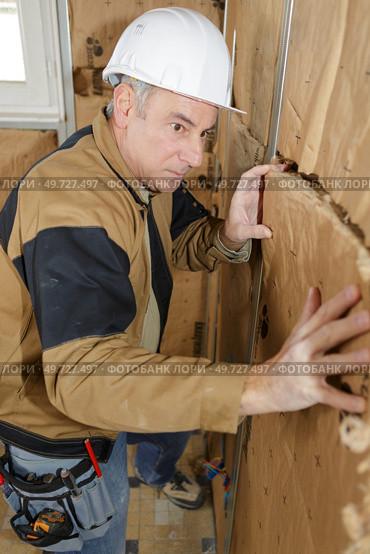 worker insulates the walls. Стоковое фото, агентство Ingram Publishing / Фотобанк Лори