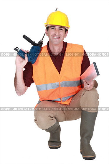 Worker kneeling with drill. Стоковое фото, агентство Ingram Publishing / Фотобанк Лори