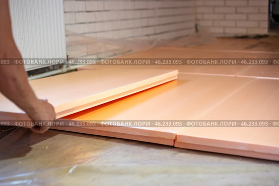 Worker lays polystyrene foam on the floor. Insulation of the house, installation of underfloor heating. Стоковое фото, фотограф Коханова Наталья / Фотобанк Лори