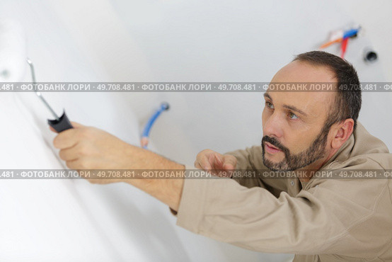 worker painting a wall in room. Стоковое фото, агентство Ingram Publishing / Фотобанк Лори