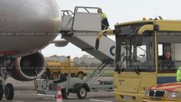 Workers fixing the flight ladder to the airplane. Сотрудники фиксируют лестничный трап самолета. (2017 год). Редакционное видео, видеограф EStarodubov / Фотобанк Лори