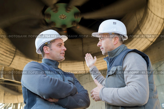 workers stood underneath industrial turbine. Стоковое фото, агентство Ingram Publishing / Фотобанк Лори