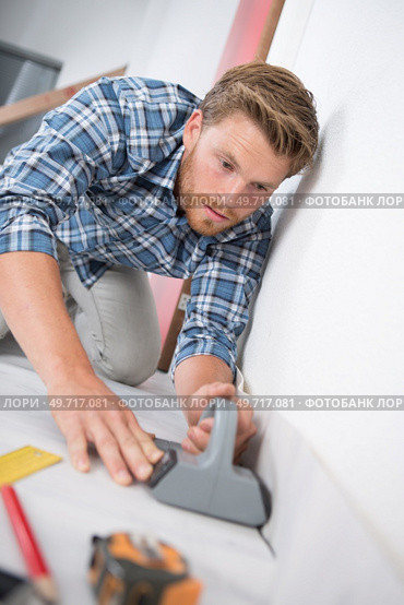 workman putting down linoleum flooring. Стоковое фото, агентство Ingram Publishing / Фотобанк Лори