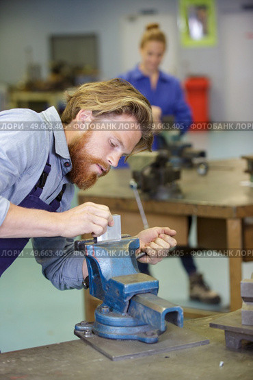 workman securing metal in a vice. Стоковое фото, агентство Ingram Publishing / Фотобанк Лори
