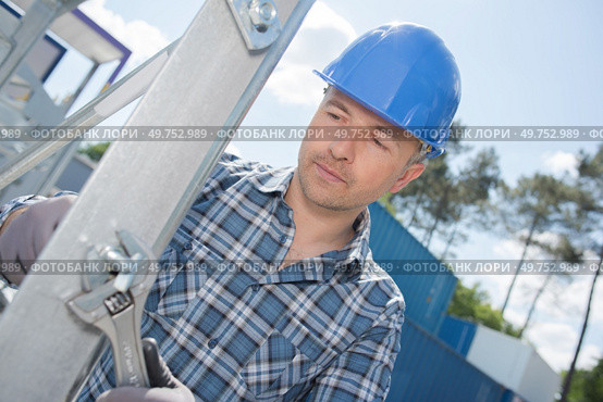 Workman tightening bolt on metal structure. Стоковое фото, агентство Ingram Publishing / Фотобанк Лори