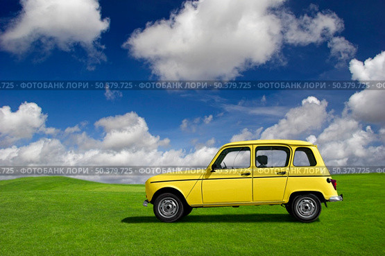Yellow classic car in a green meadow. Стоковое фото, агентство Ingram Publishing / Фотобанк Лори