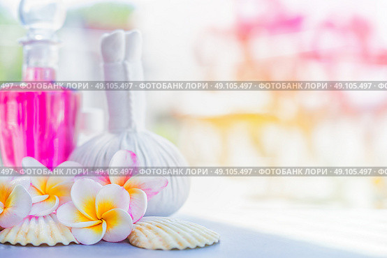 Yellow Frangipani flowers  with herbal compress stamps , pink lotion bottle and shells at summer nature background. Spa or wellness background. Стоковое фото, агентство Ingram Publishing / Фотобанк Лори