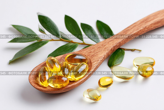 Yellow Pills in a wood spoon. Vitamin D. White background. Big golden tablets. Omega 3 capsules. Healthy every day fatty acid. Food supplement fish oil. Human health benefits product banner. Nutrients. Стоковое AI-изображение, AI-художник Марина Демидюк / Фотобанк Лори
