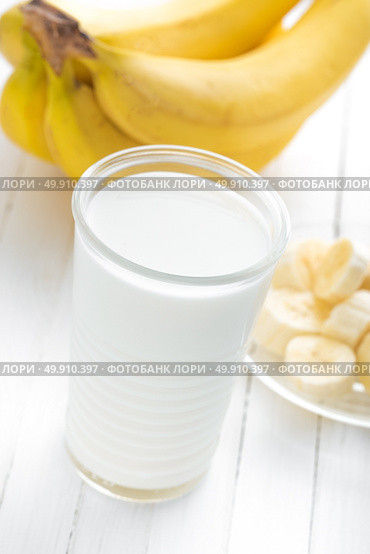 Yogurt with fresh bananas on white wooden background closeup, healthy breakfast. Стоковое фото, агентство Ingram Publishing / Фотобанк Лори