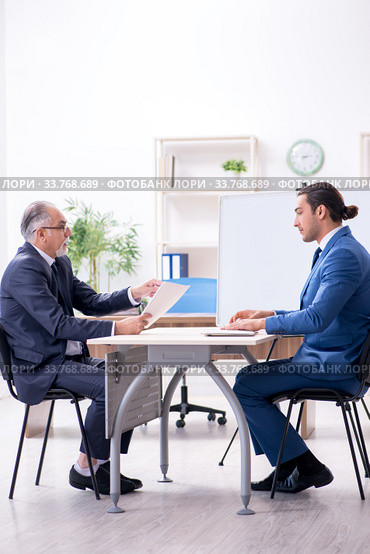 Yound and old employees in business presentation concept. Стоковое фото, фотограф Elnur / Фотобанк Лори