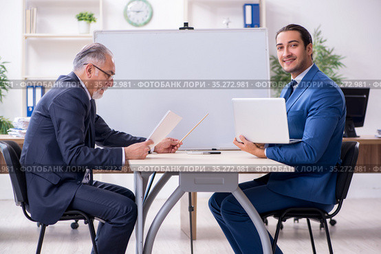 Yound and old employees in business presentation concept. Стоковое фото, фотограф Elnur / Фотобанк Лори