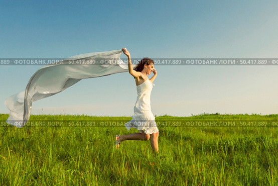 Young beautiful woman running while holding a white tissue. Стоковое фото, агентство Ingram Publishing / Фотобанк Лори