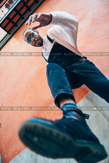 Young black man man kicking towards the ground. Lifestyle concept.. Young black man man kicking towards the ground. Стоковое фото, агентство Ingram Publishing / Фотобанк Лори
