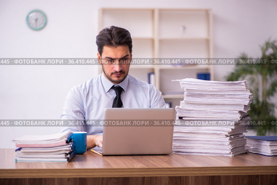 Young businessman employee unhappy with excessive work in the office. Стоковое фото, фотограф Elnur / Фотобанк Лори