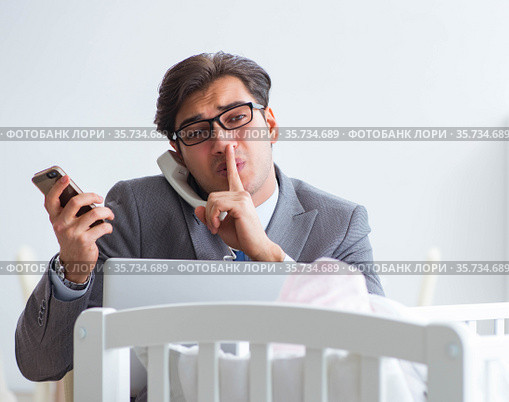 Young businessman trying to work from home caring after newborn. Стоковое фото, фотограф Elnur / Фотобанк Лори