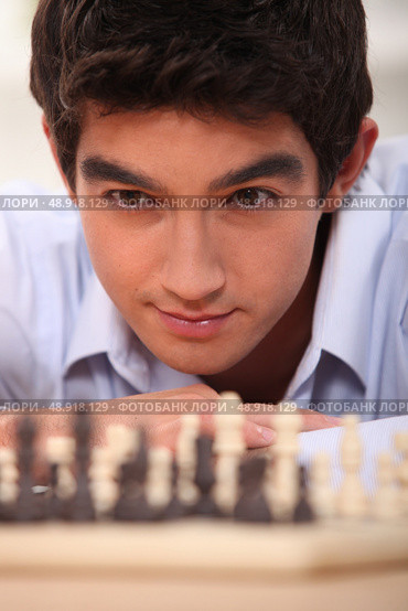 young chessplayer looking focused. Стоковое фото, агентство Ingram Publishing / Фотобанк Лори