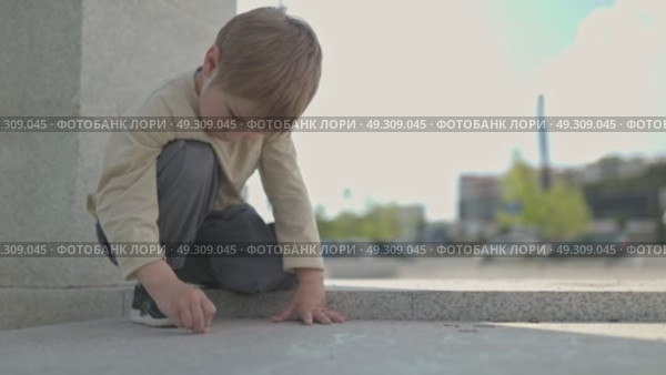 Young child drawing with chalk on pavement. Стоковое видео, видеограф Константин Шишкин / Фотобанк Лори