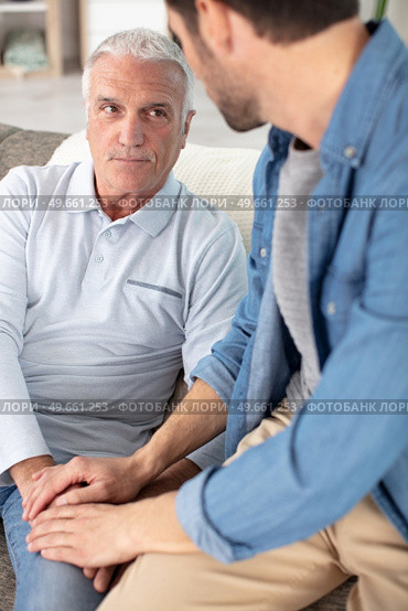 young compassionate man holding hand of unhappy elderly senior father. Стоковое фото, агентство Ingram Publishing / Фотобанк Лори