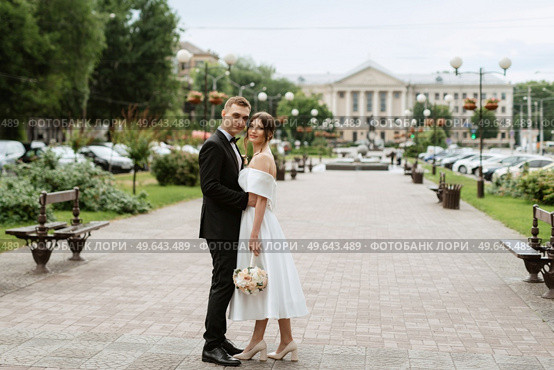 young couple bride and groom in a white short dress walking in the rain. Стоковое фото, агентство Ingram Publishing / Фотобанк Лори