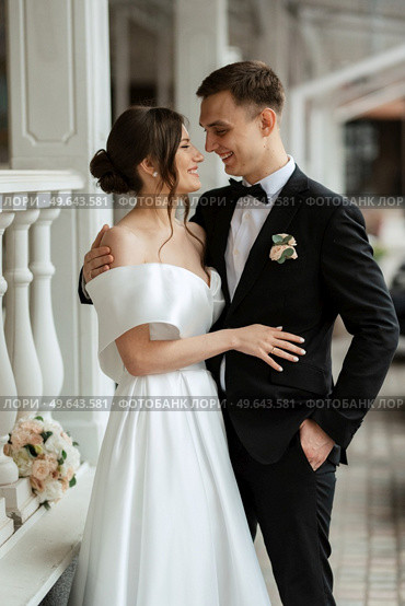 young couple bride and groom in a white short dress walking in the rain. Стоковое фото, агентство Ingram Publishing / Фотобанк Лори