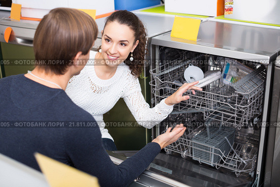 young couple choosing new dish washing machine in appliance store. Стоковое фото, фотограф Яков Филимонов / Фотобанк Лори