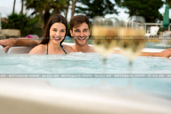 Young couple inside a jacuzzi and tasting wine. Стоковое фото, агентство Ingram Publishing / Фотобанк Лори