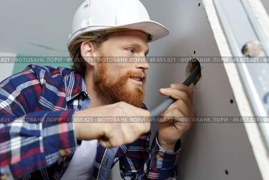young electrician installer working with cable. Стоковое фото, агентство Ingram Publishing / Фотобанк Лори