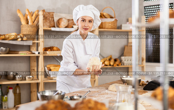 Young female baker kneading dough on table. Стоковое фото, фотограф Яков Филимонов / Фотобанк Лори