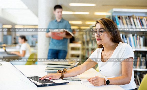 Young female hispanic student studying with a laptop. Стоковое фото, фотограф Яков Филимонов / Фотобанк Лори