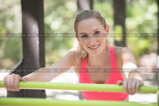 young fitness woman leaning to wall bars outdoors. Стоковое фото, агентство Ingram Publishing / Фотобанк Лори