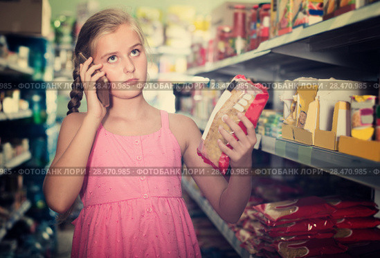 Young girl is advised by phone what pasta she should buy. Стоковое фото, фотограф Яков Филимонов / Фотобанк Лори