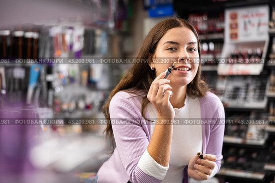 Young girl testing face concealer in beauty store. Стоковое фото, фотограф Яков Филимонов / Фотобанк Лори