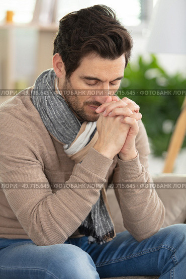 young handsome man begging and praying with hands together. Стоковое фото, агентство Ingram Publishing / Фотобанк Лори