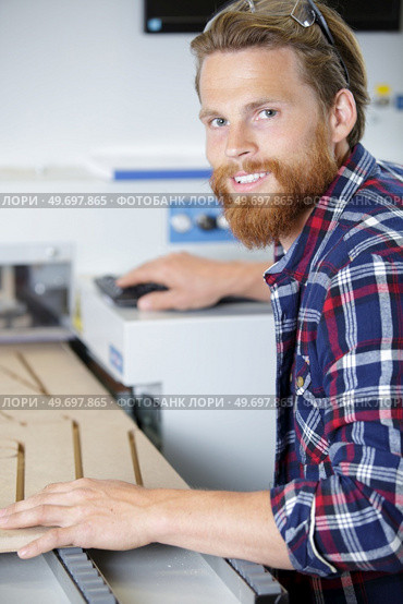 young happy man using a wood shaper. Стоковое фото, агентство Ingram Publishing / Фотобанк Лори