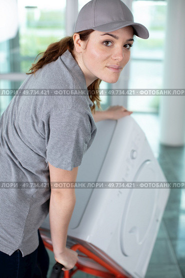 young happy woman carrying washer in kitchen. Стоковое фото, агентство Ingram Publishing / Фотобанк Лори