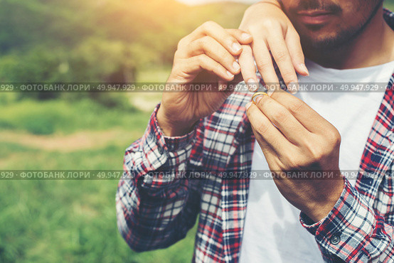 Young hipster couple wearing engagement ring in nature,Sweet and. Young hipster couple wearing engagement ring in nature,Sweet and a good time in life. Happy and very grateful. Стоковое фото, агентство Ingram Publishing / Фотобанк Лори