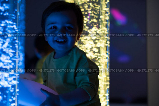Young kid exploring snoezelen space. Young kid exploring a multi sensory space - snoezelen concept. Стоковое фото, агентство Ingram Publishing / Фотобанк Лори