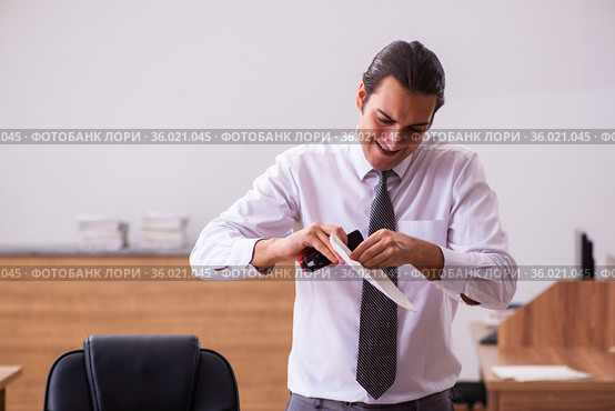 Young male employee stapling paper in the office. Стоковое фото, фотограф Elnur / Фотобанк Лори