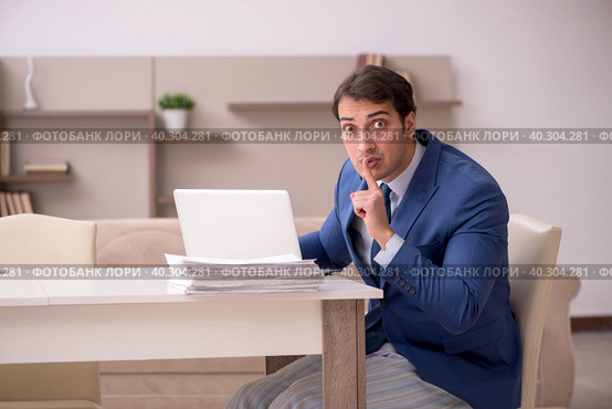Young male employee working from home during pandemic. Стоковое фото, фотограф Elnur / Фотобанк Лори