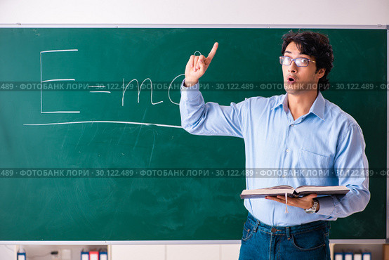 Young male physic standing in front of the green board. Стоковое фото, фотограф Elnur / Фотобанк Лори