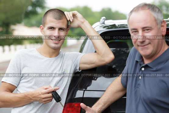 young male white driver is holding new car key. Стоковое фото, агентство Ingram Publishing / Фотобанк Лори