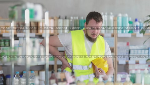 Young man builder with back pain at pharmacy. Стоковое видео, видеограф Яков Филимонов / Фотобанк Лори